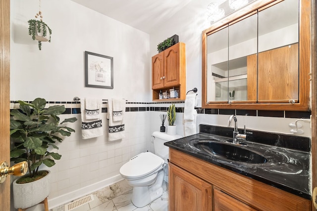 2626 E Martha Pl, Burnham, IL 60633 - bathroom featuring vanity, marble finish flooring, tile walls, and wainscoting