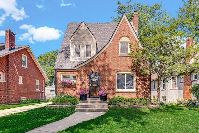 9146 S Hamilton Ave, Chicago, IL 60643 - tudor home featuring a front lawn, brick siding, a shingled roof, and a chimney