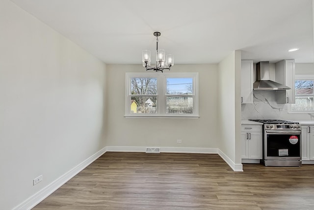 2024 E Wintergreen Ave, Mount Prospect, IL 60056 - kitchen featuring wall chimney exhaust hood, high end range, a chandelier, light wood-style floors, and recessed lighting