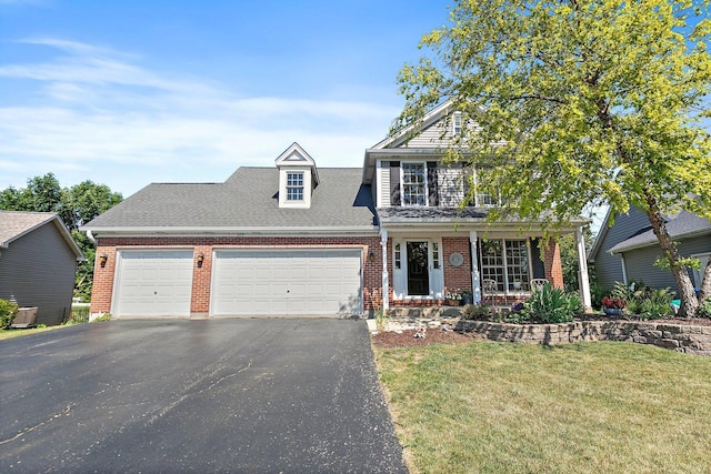 105 Devonshire Dr, Dekalb, IL 60115 - traditional-style house with brick siding, an attached garage, asphalt driveway, and a front lawn