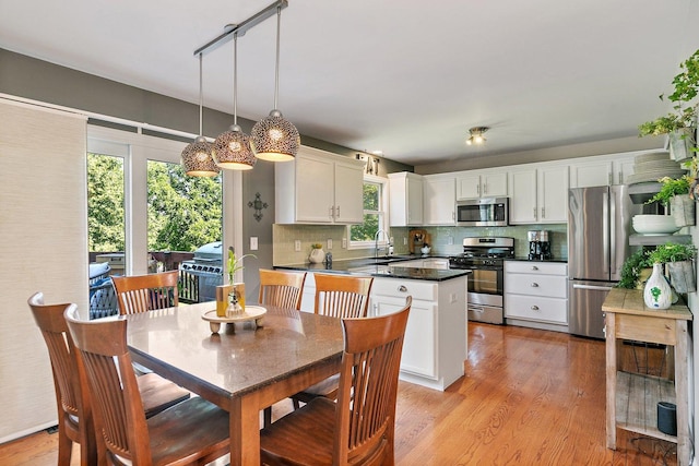 105 Devonshire Dr, Dekalb, IL 60115 - kitchen featuring appliances with stainless steel finishes, dark countertops, white cabinetry, light wood finished floors, and decorative backsplash