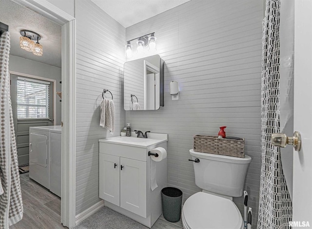 145 White Ave, Lincoln, IL 62656 - bathroom with vanity, washer and clothes dryer, wood finished floors, and a textured ceiling