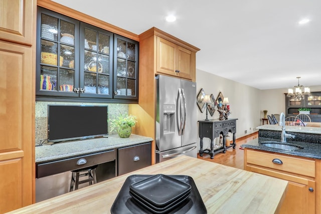 330 Dorchester Ln, Grayslake, IL 60030 - kitchen featuring stainless steel refrigerator with ice dispenser, glass insert cabinets, light stone counters, a chandelier, and wood finished floors