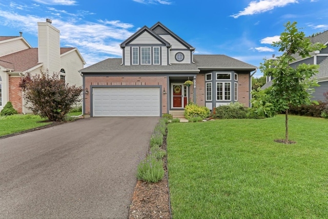 330 Dorchester Ln, Grayslake, IL 60030 - traditional-style house featuring asphalt driveway, a front lawn, a garage, roof with shingles, and brick siding