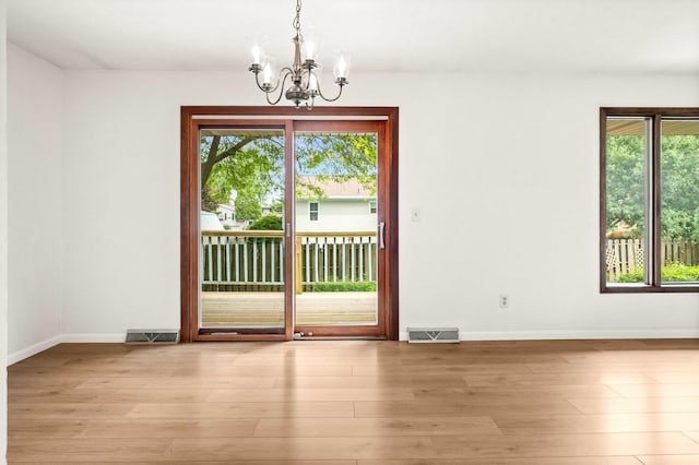 1219 Nicki Dr, Bloomington, IL 61704 - unfurnished room with a chandelier, healthy amount of natural light, and light wood-style flooring
