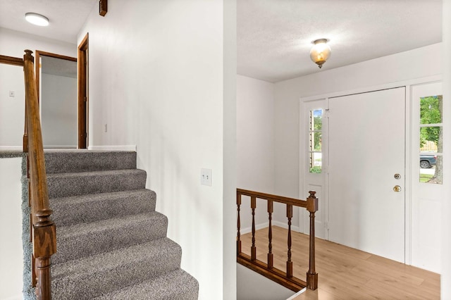 1219 Nicki Dr, Bloomington, IL 61704 - entryway featuring light wood-type flooring, stairs, and a textured ceiling