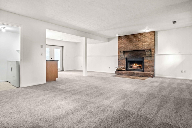 1219 Nicki Dr, Bloomington, IL 61704 - unfurnished living room featuring carpet, a fireplace, a textured ceiling, and washer / dryer