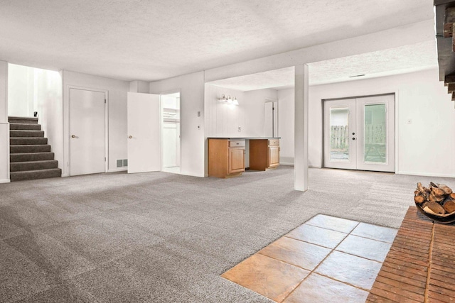 1219 Nicki Dr, Bloomington, IL 61704 - unfurnished living room with stairs, a textured ceiling, carpet, and french doors