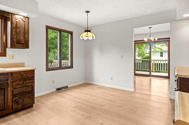 1219 Nicki Dr, Bloomington, IL 61704 - unfurnished dining area featuring healthy amount of natural light, a chandelier, and light wood-style floors