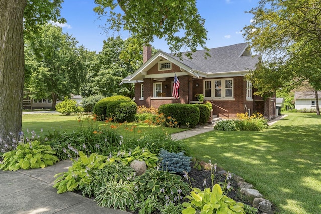 321 W Chebanse Ave, Chebanse, IL 60922 - view of front facade with brick siding, a chimney, a front yard, and a shingled roof