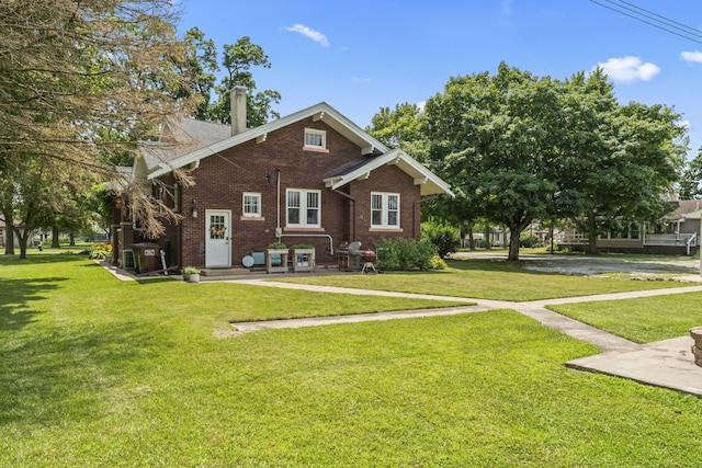 321 W Chebanse Ave, Chebanse, IL 60922 - rear view of property featuring brick siding, a chimney, and a yard