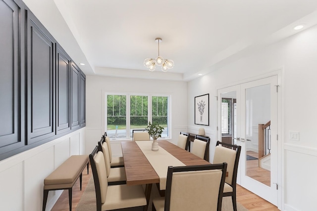 16540 Pear Ave, Orland Park, IL 60467 - dining space with a decorative wall, a chandelier, light wood-style flooring, french doors, and a raised ceiling