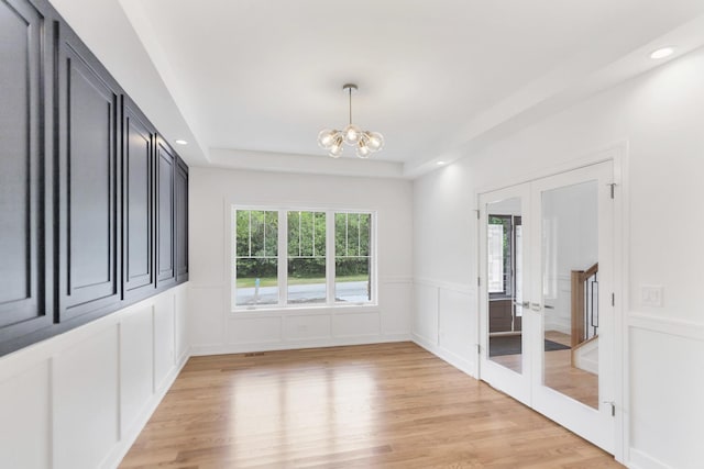 16540 Pear Ave, Orland Park, IL 60467 - spare room with a chandelier, a decorative wall, light wood-type flooring, french doors, and a raised ceiling