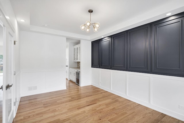 16540 Pear Ave, Orland Park, IL 60467 - spare room with a decorative wall, a chandelier, light wood-style flooring, beverage cooler, and recessed lighting