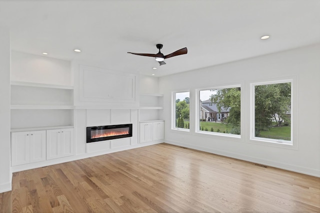 16540 Pear Ave, Orland Park, IL 60467 - unfurnished living room with a glass covered fireplace, light wood-type flooring, ceiling fan, recessed lighting, and built in shelves