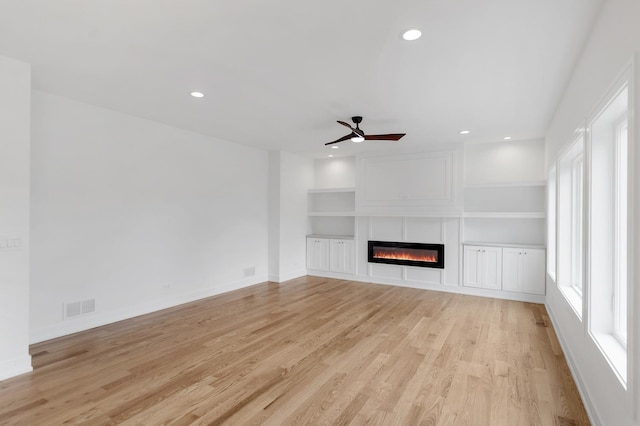 16540 Pear Ave, Orland Park, IL 60467 - unfurnished living room with a glass covered fireplace, light wood-style flooring, recessed lighting, ceiling fan, and built in shelves