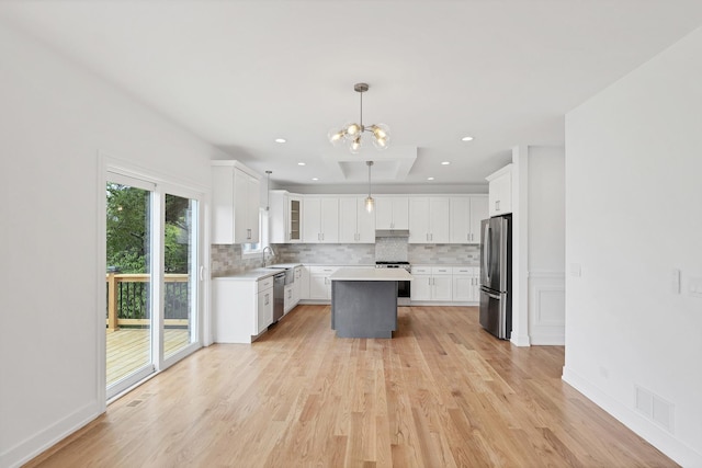 16540 Pear Ave, Orland Park, IL 60467 - kitchen featuring stainless steel appliances, tasteful backsplash, light countertops, white cabinetry, and a kitchen island