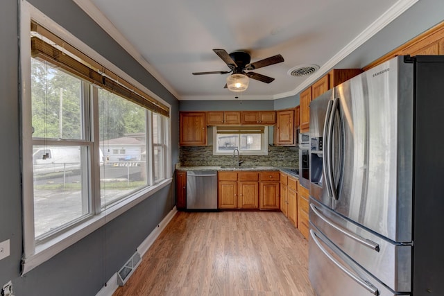 16218 Sussex Ct, Markham, IL 60428 - kitchen with stainless steel appliances, brown cabinets, a ceiling fan, decorative backsplash, and light wood-type flooring