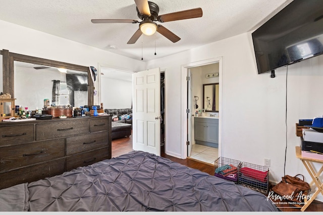 245 N 6th Ave, Kankakee, IL 60901 - bedroom featuring wood finished floors, a ceiling fan, connected bathroom, and a textured ceiling