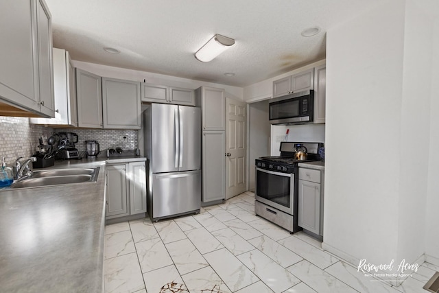 245 N 6th Ave, Kankakee, IL 60901 - kitchen with appliances with stainless steel finishes, gray cabinetry, light marble finish floors, and decorative backsplash