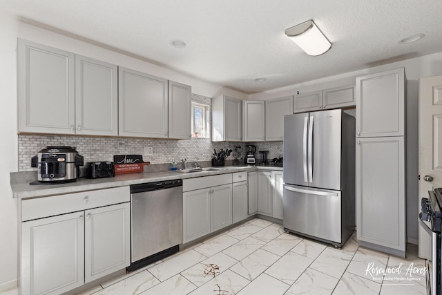 245 N 6th Ave, Kankakee, IL 60901 - kitchen featuring stainless steel appliances, gray cabinetry, light marble finish flooring, backsplash, and light countertops