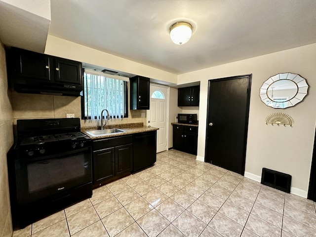 39 Leonard St, Elgin, IL 60123 - kitchen with black appliances, dark cabinetry, under cabinet range hood, light tile patterned flooring, and decorative backsplash