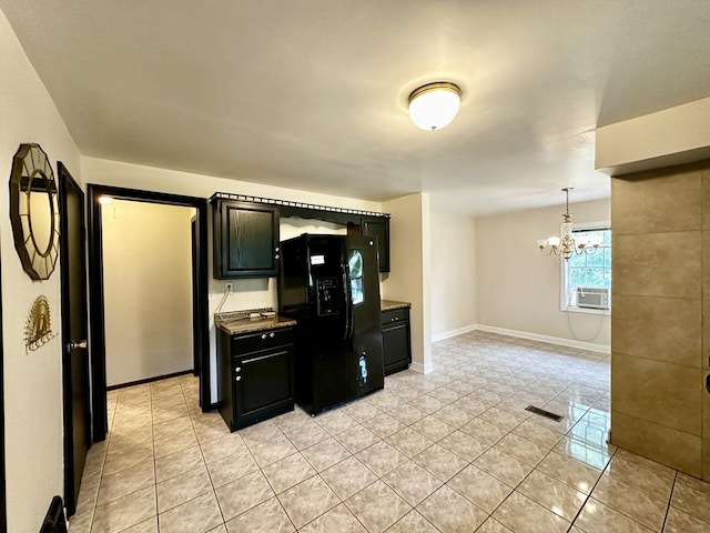 39 Leonard St, Elgin, IL 60123 - kitchen with black fridge, light tile patterned floors, a chandelier, and dark cabinetry