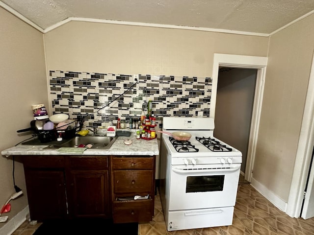 39 Leonard St, Elgin, IL 60123 - kitchen featuring white gas stove, light countertops, a textured ceiling, dark brown cabinetry, and lofted ceiling