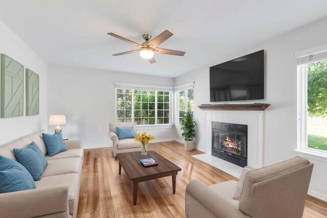 1356 Geneva Ln, Cary, IL 60013 - living area featuring light wood finished floors, a glass covered fireplace, and a ceiling fan