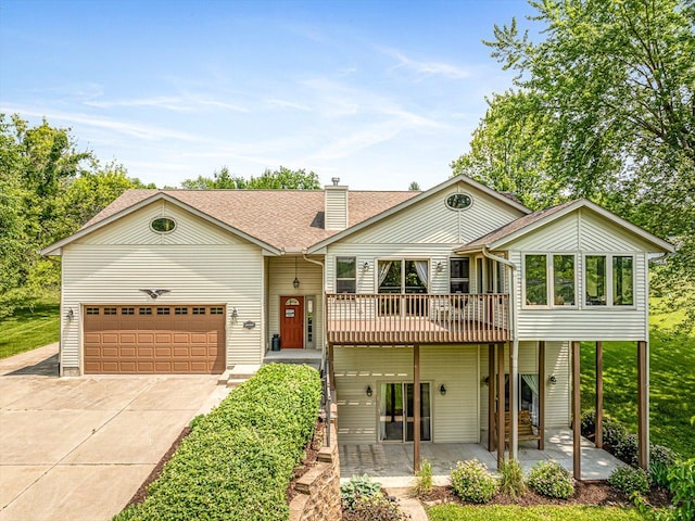 1375 Coven Cir, Davis, IL 61019 - view of front of property featuring concrete driveway, a garage, a chimney, a shingled roof, and a deck