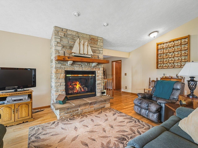 1375 Coven Cir, Davis, IL 61019 - living room featuring a textured ceiling, a stone fireplace, light wood-style floors, and vaulted ceiling