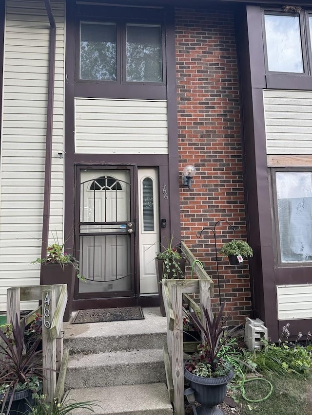 doorway to property with brick siding