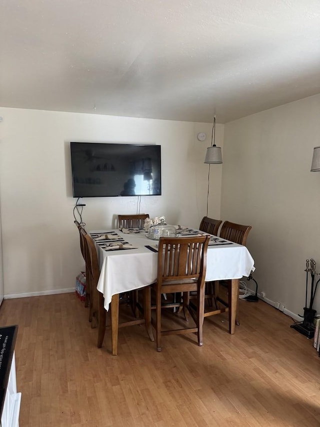 dining space with light wood-style floors and baseboards