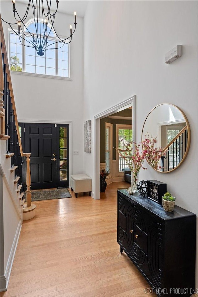 25660 N Countryside Dr, Lake Barrington, IL 60010 - foyer featuring stairway, light wood-style flooring, a chandelier, and a towering ceiling