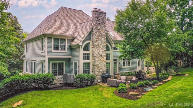 25660 N Countryside Dr, Lake Barrington, IL 60010 - rear view of property featuring a chimney, a yard, stone siding, an outdoor living space, and a patio