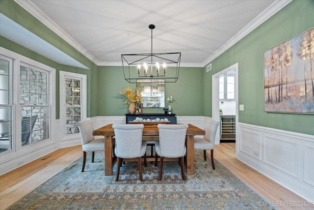 25660 N Countryside Dr, Lake Barrington, IL 60010 - dining space featuring wood finished floors, crown molding, a chandelier, and wainscoting