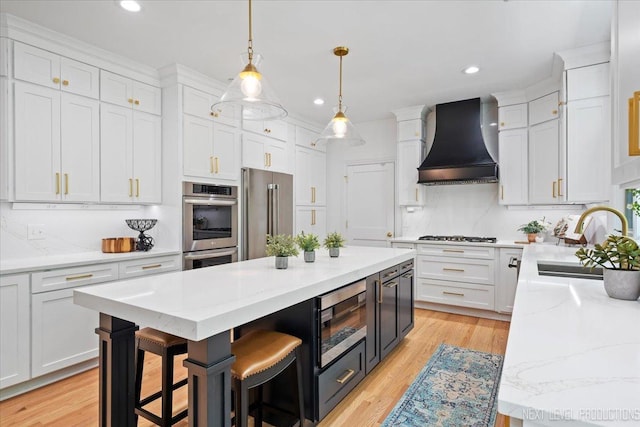 25660 N Countryside Dr, Lake Barrington, IL 60010 - kitchen featuring premium range hood, appliances with stainless steel finishes, white cabinetry, a kitchen island, and recessed lighting