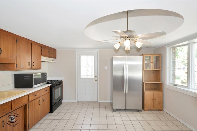 7235 174th Pl, Tinley Park, IL 60477 - kitchen with freestanding refrigerator, black range with gas stovetop, under cabinet range hood, light countertops, and brown cabinetry