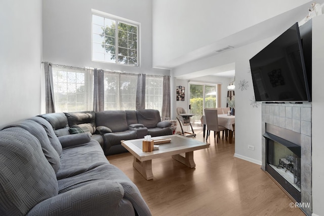 1261 River Ash Ct, Bartlett, IL 60103 - living area featuring light wood-style flooring, a towering ceiling, and a fireplace