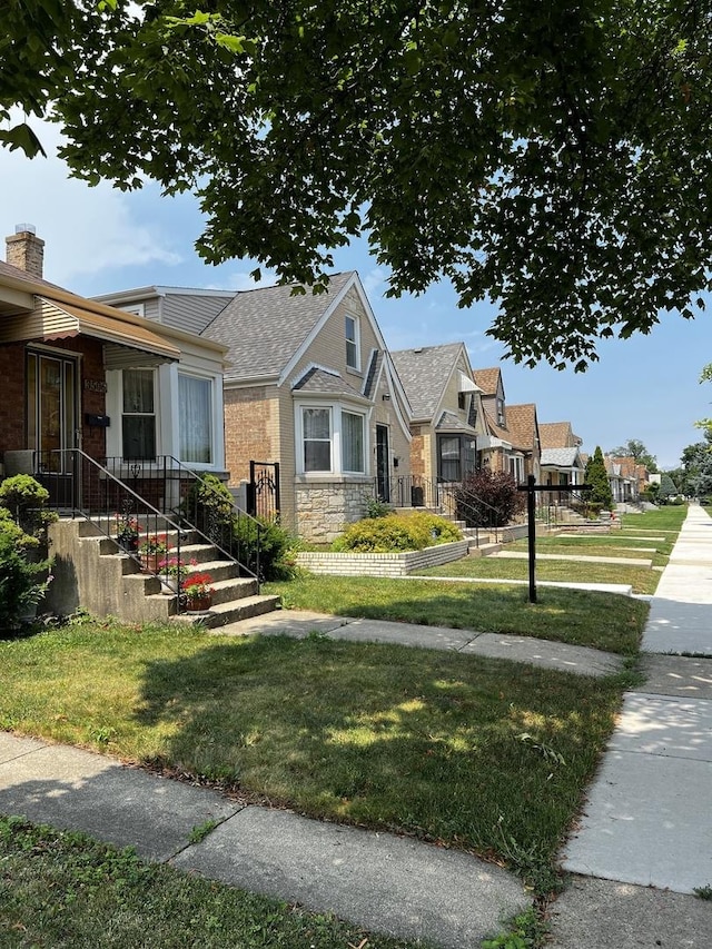 3506 N Rutherford Ave, Chicago, IL 60634 - view of front of house featuring a front yard, stone siding, roof with shingles, and a residential view