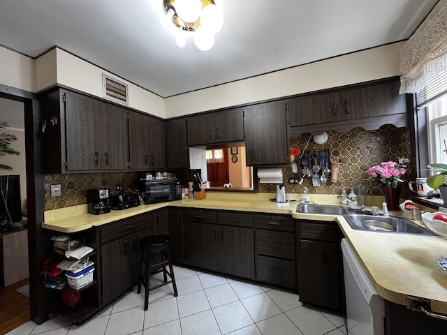3506 N Rutherford Ave, Chicago, IL 60634 - kitchen featuring light tile patterned floors, light countertops, tasteful backsplash, white dishwasher, and dark brown cabinets