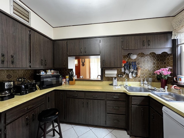 3506 N Rutherford Ave, Chicago, IL 60634 - kitchen with white dishwasher, light tile patterned flooring, dark brown cabinets, and light countertops