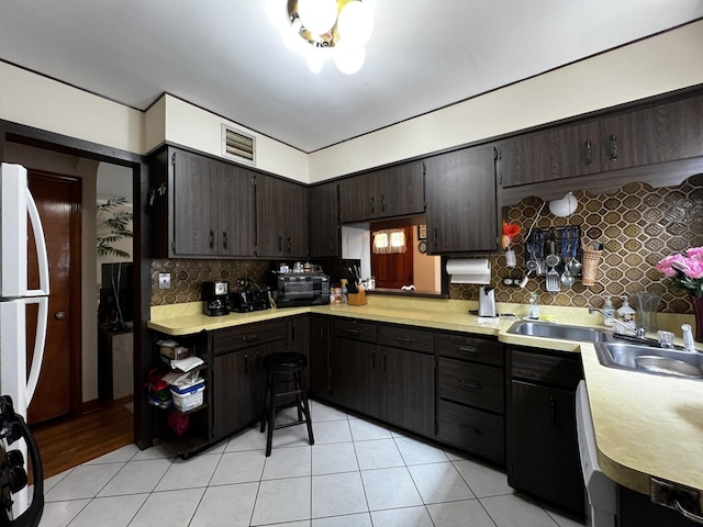 3506 N Rutherford Ave, Chicago, IL 60634 - kitchen with tasteful backsplash, light countertops, light tile patterned floors, and dark brown cabinetry