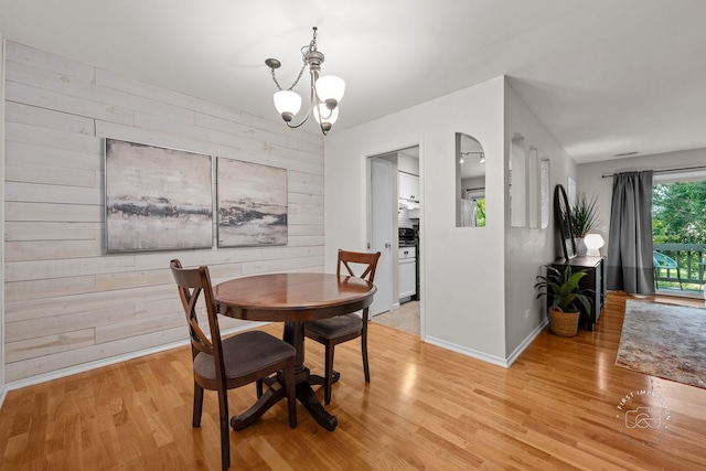 29W440 Emerald Green Dr Unit 25-F, Warrenville, IL 60555 - dining space featuring a chandelier, light wood finished floors, and wooden walls