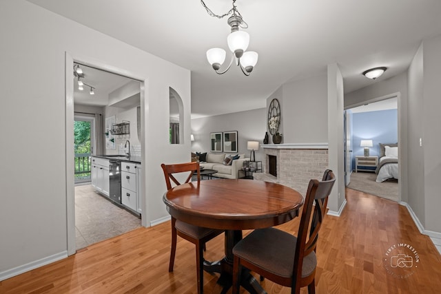 29W440 Emerald Green Dr Unit 25-F, Warrenville, IL 60555 - dining room with light wood-type flooring, a chandelier, and a fireplace
