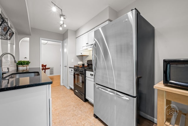 29W440 Emerald Green Dr Unit 25-F, Warrenville, IL 60555 - kitchen with gas stove, freestanding refrigerator, white cabinetry, under cabinet range hood, and dark stone counters