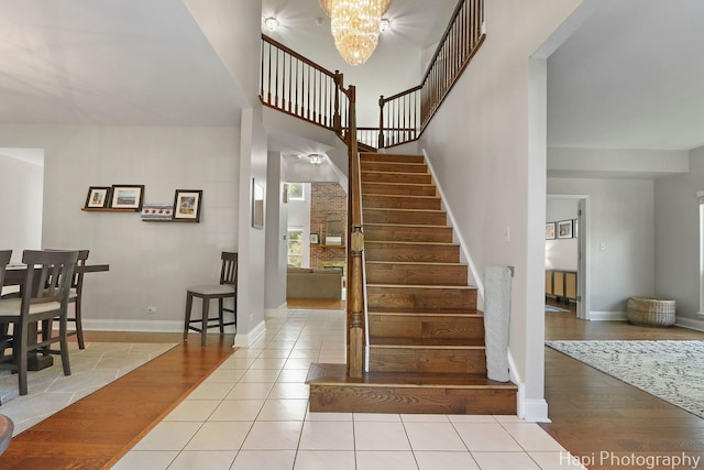 232 Bobolink Dr, Grayslake, IL 60030 - stairs featuring a chandelier, tile patterned floors, and a towering ceiling