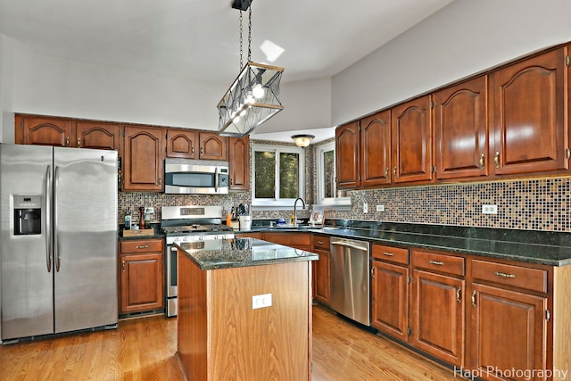 232 Bobolink Dr, Grayslake, IL 60030 - kitchen featuring appliances with stainless steel finishes, light wood-style floors, a center island, tasteful backsplash, and decorative light fixtures