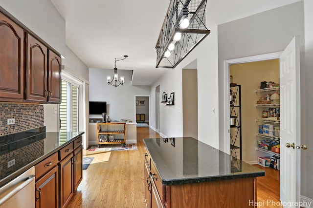 232 Bobolink Dr, Grayslake, IL 60030 - kitchen featuring light wood-type flooring, a chandelier, dark stone countertops, a kitchen island, and decorative light fixtures