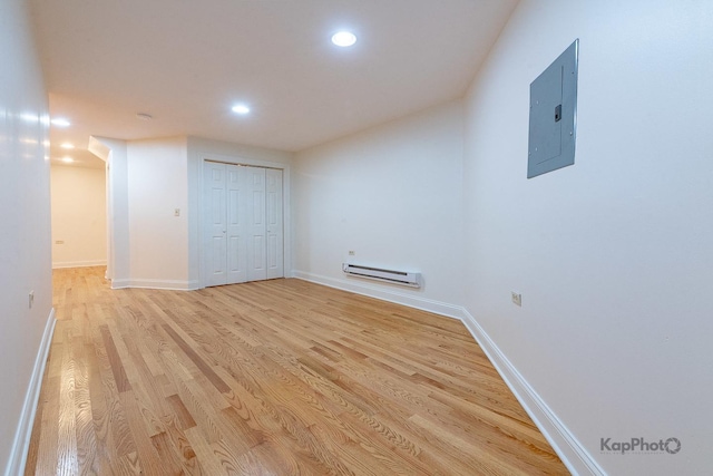 2318 S Central Park Ave Unit 101, Chicago, IL 60623 - empty room with electric panel, a baseboard radiator, light wood-style floors, and recessed lighting